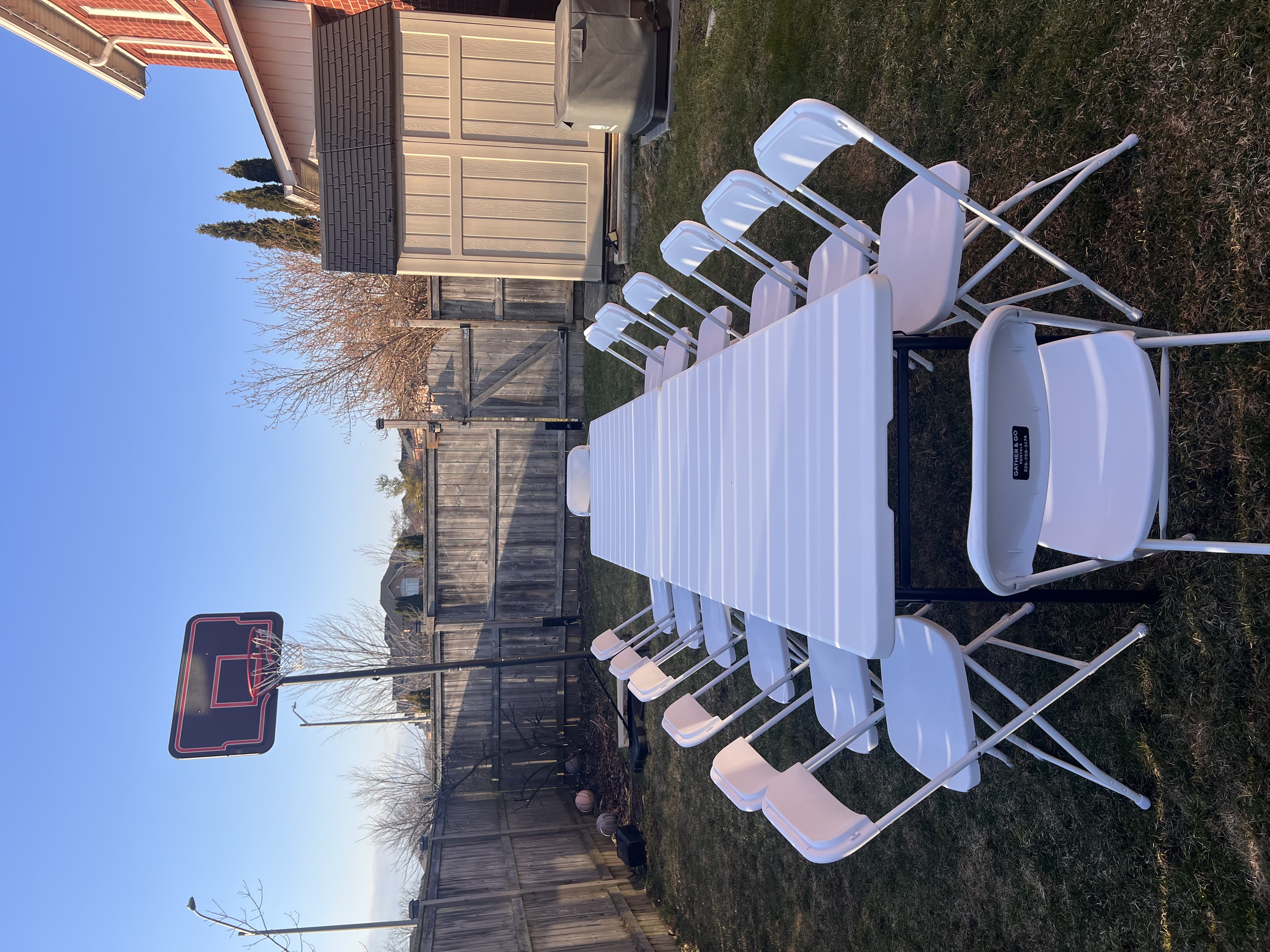 White folding chairs and banquet table rental setup in backyard - table and chair rentals GTA and Durham Region - Gather and Go Rentals